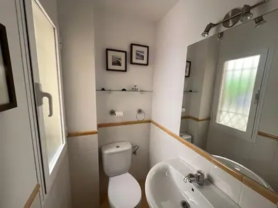 a white bathroom with a toilet and a sink at GINVA - Dúplex en Plaza de España in El Puerto de Santa María