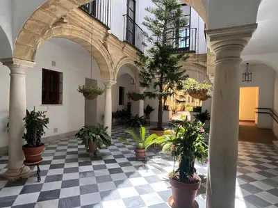 a courtyard with potted plants in a building at GINVA - Dúplex en Plaza de España in El Puerto de Santa María