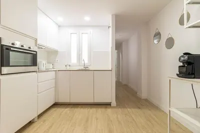 a white kitchen with white cabinets and a microwave at Allo Apartments Morenos II 1ºC Centro 2 Habitaciones in Jerez de la Frontera