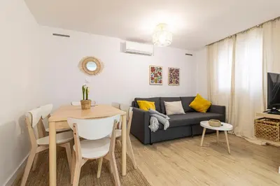 a living room with a table and a couch at Allo Apartments Morenos II 1ºC Centro 2 Habitaciones in Jerez de la Frontera