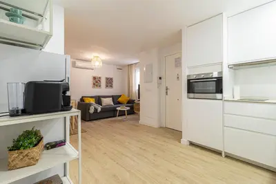 a living room with a kitchen and a couch at Allo Apartments Morenos II 1ºC Centro 2 Habitaciones in Jerez de la Frontera