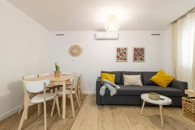 a living room with a couch and a table at Allo Apartments Morenos II 1ºC Centro 2 Habitaciones in Jerez de la Frontera