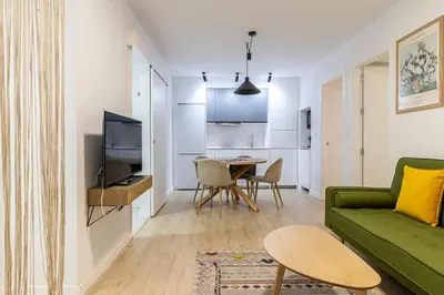 a living room with a green couch and a table at Allo Apartments Morenos III Bajo A Centro 2 Habitaciones in Jerez de la Frontera