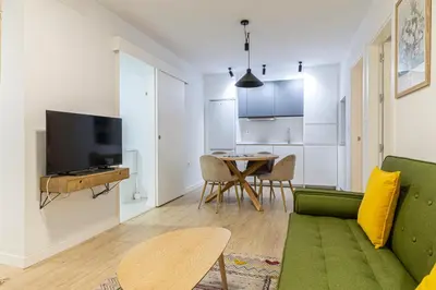 a living room with a green couch and a table at Allo Apartments Morenos III Bajo A Centro 2 Habitaciones in Jerez de la Frontera