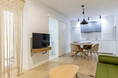 a living room with a green couch and a table at Allo Apartments Morenos III Bajo A Centro 2 Habitaciones in Jerez de la Frontera
