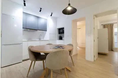 a kitchen and dining room with a wooden table and chairs at Allo Apartments Morenos III Bajo A Centro 2 Habitaciones in Jerez de la Frontera