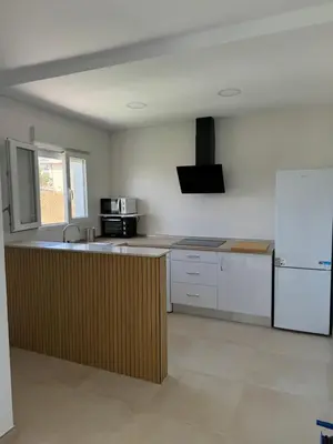 a kitchen with white cabinets and a sink and a microwave at Apartamento El Oasis in Chiclana de la Frontera