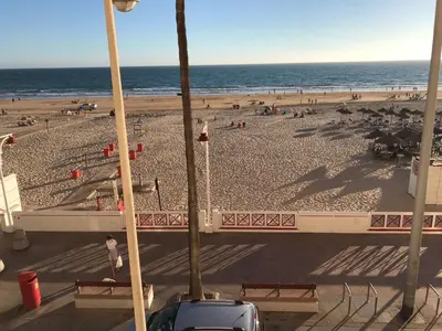 a view of a beach with people and the ocean at Mirando al Mar con Wifi y Terraza 1ª línea playa in Cádiz