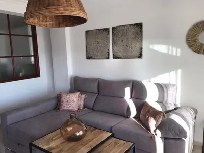 a living room with a couch and a table at Mirando al Mar con Wifi y Terraza 1ª línea playa in Cádiz