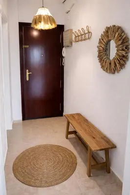 a wooden bench sitting in front of a door at Mirando al Mar con Wifi y Terraza 1ª línea playa in Cádiz