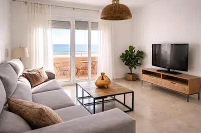 a living room with a couch and a flat screen tv at Mirando al Mar con Wifi y Terraza 1ª línea playa in Cádiz