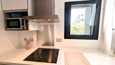 a kitchen with a sink and a microwave and a window at Rincón del Atlántico in Rota