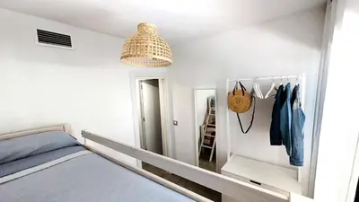 a bedroom with a bed and a chandelier at Rincón del Atlántico in Rota