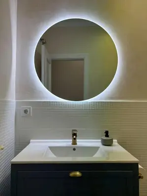 a bathroom with a sink and a round mirror at Apartamento en el centro histórico in El Puerto de Santa María