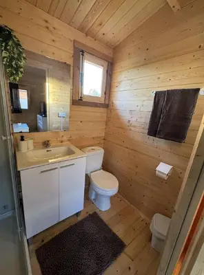 a wooden bathroom with a toilet and a sink at Bungalow Sol in Chiclana de la Frontera