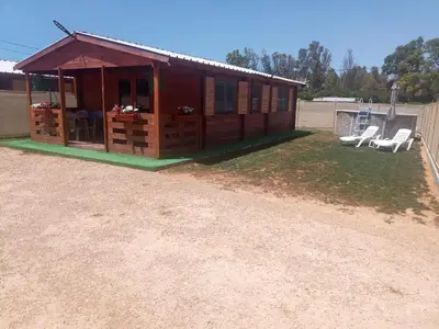a small house with a porch and two chairs at Bungalow Sol in Chiclana de la Frontera