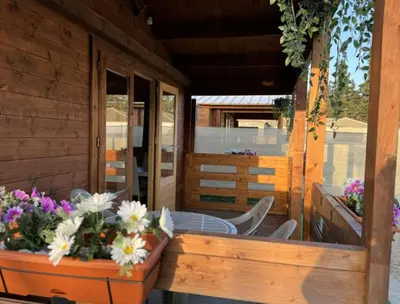 a porch of a house with a table and flowers at Bungalow Sol in Chiclana de la Frontera