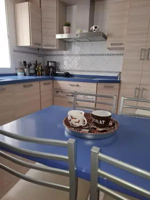 a kitchen with a blue table with two cups on it at Apartamento céntrico con garaje opcional in Sanlúcar de Barrameda