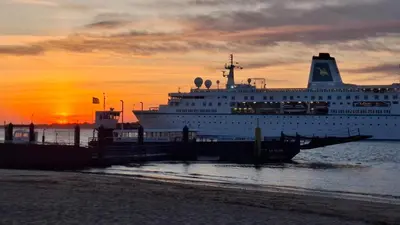 a cruise ship docked at a dock at sunset at Apartamento céntrico con garaje opcional in Sanlúcar de Barrameda