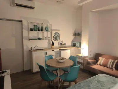 a kitchen and a living room with a table and chairs at Casa Cervera in San Fernando