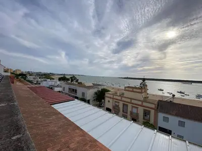 a view of the ocean from the roofs of buildings at Apartamento Malandar in Sanlúcar de Barrameda