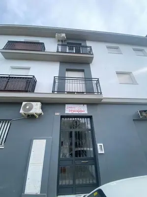 a blue building with a window and a balcony at Apartamento Malandar in Sanlúcar de Barrameda