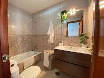 a bathroom with a tub and a toilet and a sink at Apartamento Malandar in Sanlúcar de Barrameda