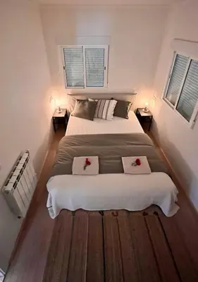 a bedroom with a large bed with two pillows on it at Abajo Stijlvol appartement met zwembad en tuin in Cádiz