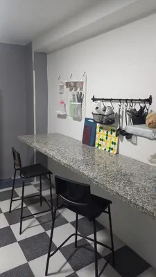 a kitchen with a counter and two black chairs at Casa del Prendi in Jerez de la Frontera