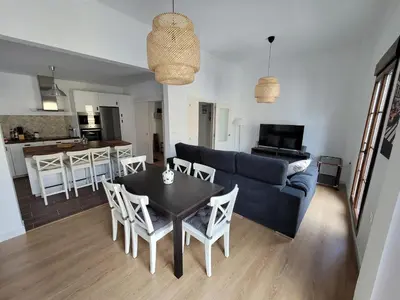a living room with a blue couch and a table and chairs at Casa Teresa in Sanlúcar de Barrameda