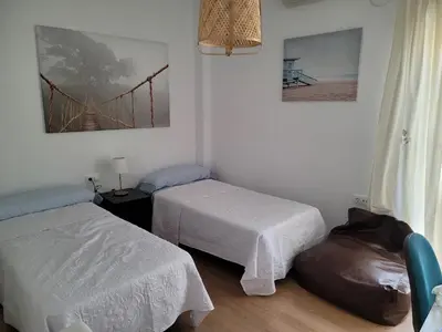 a room with two beds and a bridge on the wall at Casa Teresa in Sanlúcar de Barrameda