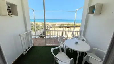 a balcony with a table and chairs and the beach at La Casa Azul in Chiclana de la Frontera