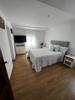a white bedroom with a bed and a television at Vino Amontillado 5 in El Puerto de Santa María