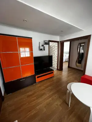a living room with an orange cabinet and a flat screen tv at Vino Amontillado 5 in El Puerto de Santa María