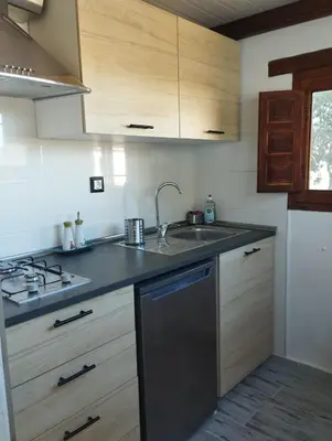 a kitchen with wooden cabinets and a sink at Casa Yuxiao rincón de tranquilidad in Cádiz