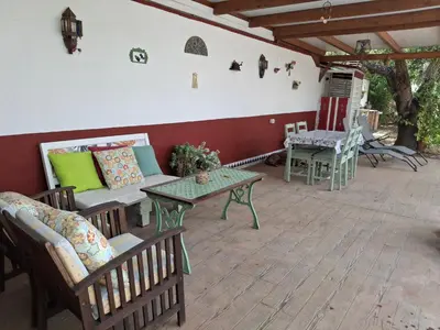 a patio with chairs and a table and a bench at Casa Yuxiao rincón de tranquilidad in Cádiz