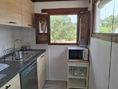 a small kitchen with a sink and a microwave at Casa Yuxiao rincón de tranquilidad in Cádiz