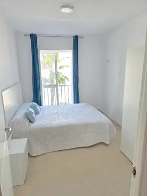 a white bedroom with a bed and a window at Piso de la Constitución de 1812 in Cádiz