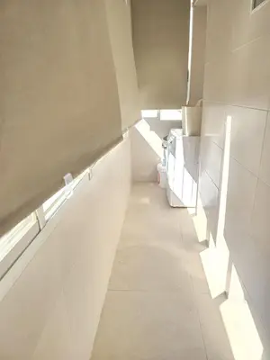 a long hallway with white walls and a window at Piso de la Constitución de 1812 in Cádiz