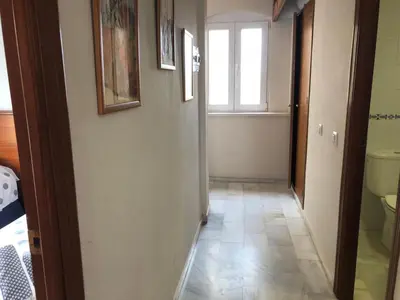 a hallway of a bathroom with a toilet and a window at Apartamento Playa La Muralla in El Puerto de Santa María