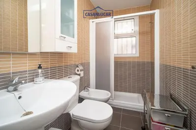 a bathroom with a white sink and a toilet at Piso de la Manzanilla in Sanlúcar de Barrameda