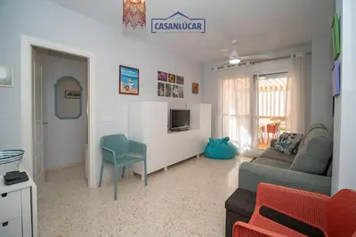a living room with a couch and a chair at Piso de la Manzanilla in Sanlúcar de Barrameda