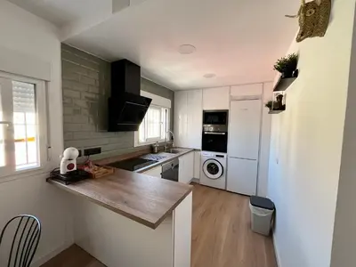 a kitchen with white cabinets and a counter top at Apartamento Pleamar in Sanlúcar de Barrameda