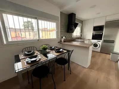 a kitchen and dining room with a table and chairs at Apartamento Pleamar in Sanlúcar de Barrameda