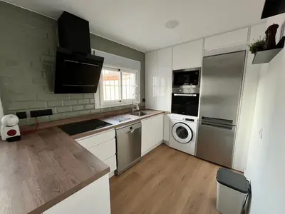 a kitchen with a refrigerator and a washer and dryer at Apartamento Pleamar in Sanlúcar de Barrameda