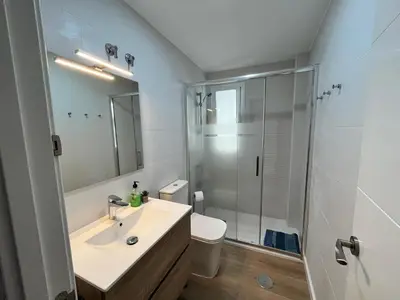 a bathroom with a sink and a glass shower at Apartamento Pleamar in Sanlúcar de Barrameda