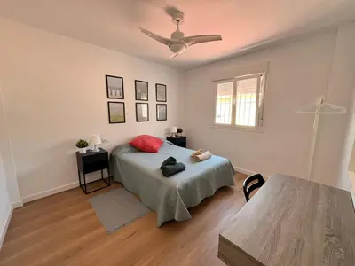 a bedroom with a bed and a ceiling fan at Apartamento Pleamar in Sanlúcar de Barrameda