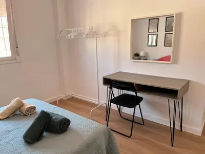 a bedroom with a desk and a bed with a table at Apartamento Pleamar in Sanlúcar de Barrameda