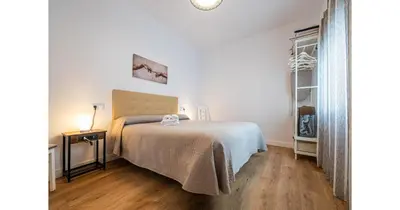 a bedroom with a bed and a wooden floor at YourHouse Apartamentos Andasol BA in Chipiona