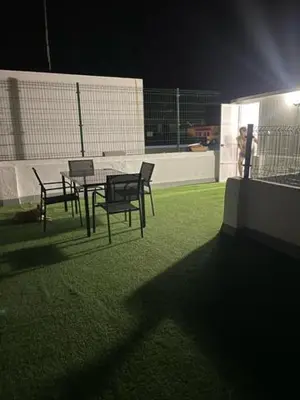 a patio with a table and chairs on the grass at YourHouse Apartamentos Andasol BA in Chipiona